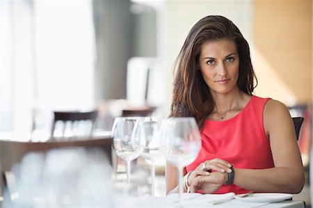 simsearch:6108-06906164,k - Woman sitting in a restaurant and looking at wristwatch Stock Photo - Premium Royalty-Free, Code: 6108-06906116