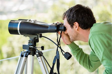 Man looking through binoculars Stock Photo - Premium Royalty-Free, Code: 6108-06906261