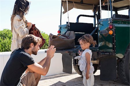 safari - Man taking a picture of his daughter with a smartphone beside a SUV Photographie de stock - Premium Libres de Droits, Code: 6108-06906283