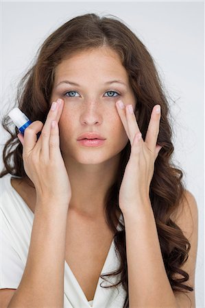 Woman checking wrinkles on her face Stock Photo - Premium Royalty-Free, Code: 6108-06906364