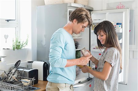 simsearch:6113-06720670,k - Couple looking at food product in front of a refrigerator in the kitchen Foto de stock - Sin royalties Premium, Código: 6108-06906415