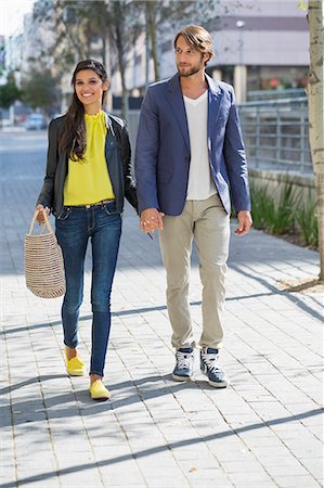 sunshine and looking away and togetherness - Happy couple walking on a street Foto de stock - Sin royalties Premium, Código: 6108-06906583