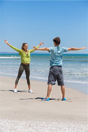 Woman and her coach exercising on the beach Stock Photo - Premium Royalty-Free, Code: 6108-06906673