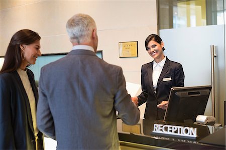 simsearch:6108-06904992,k - Business couple checking into hotel Stock Photo - Premium Royalty-Free, Code: 6108-06906690