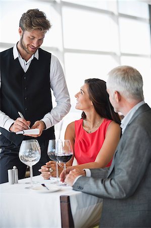 restaurant and tables - Waiter taking orders from a couple in a restaurant Stock Photo - Premium Royalty-Free, Code: 6108-06906696