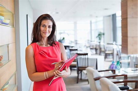 restaurant - Portrait of a waitress holding a file in a restaurant Stock Photo - Premium Royalty-Free, Code: 6108-06906698