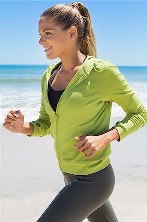physical fitness (activity) - Smiling woman running on the beach Stock Photo - Premium Royalty-Free, Code: 6108-06906626