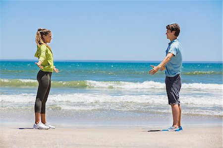 simsearch:6108-06906936,k - Woman exercising on the beach with her coach Photographie de stock - Premium Libres de Droits, Code: 6108-06906633