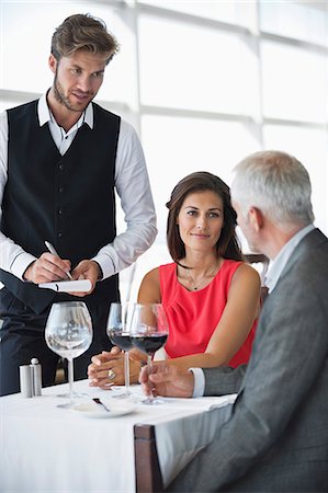 serving food at restaurant - Waiter taking orders from a couple in a restaurant Stock Photo - Premium Royalty-Free, Code: 6108-06906767