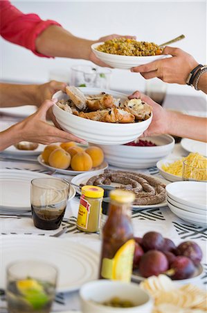 four hands - Friends having lunch at a dining table Stock Photo - Premium Royalty-Free, Code: 6108-06906781