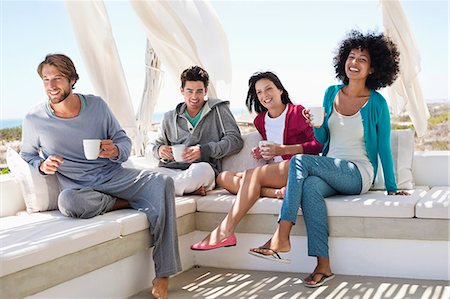 drinking sitting - Smiling friends enjoying coffee on the terrace Stock Photo - Premium Royalty-Free, Code: 6108-06906795