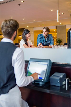 service with smile cashier - Couple at checkout counter in a restaurant Stock Photo - Premium Royalty-Free, Code: 6108-06906712