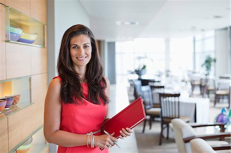 standing on a table - Portrait of a waitress holding a file in a restaurant Stock Photo - Premium Royalty-Free, Code: 6108-06906714