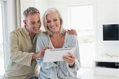 seniors - Smiling senior couple using a digital tablet Foto de stock - Sin royalties Premium, Código: 6108-06906850