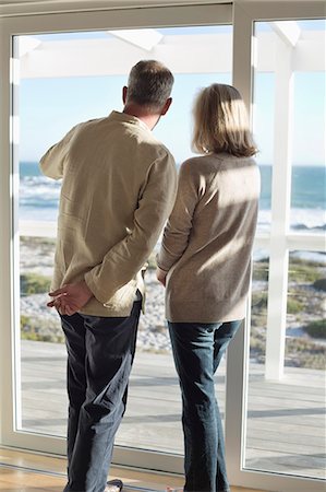 senior man back view - Couple looking through a window Stock Photo - Premium Royalty-Free, Code: 6108-06906854