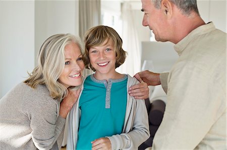 Grandparents hugging their grandson at home Foto de stock - Sin royalties Premium, Código: 6108-06906879