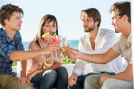 Group of friends toasting drinks outdoors on vacation Photographie de stock - Premium Libres de Droits, Code: 6108-06906805