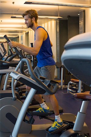 simsearch:6108-06906994,k - Man exercising on a machine in a gym Foto de stock - Sin royalties Premium, Código: 6108-06906984