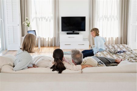 family sitting in couch - Family watching television together Stock Photo - Premium Royalty-Free, Code: 6108-06906900