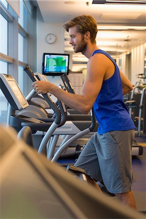 simsearch:6108-06906994,k - Man exercising on a machine in a gym Foto de stock - Sin royalties Premium, Código: 6108-06906917