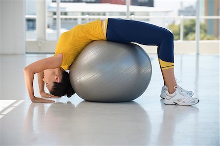 simsearch:6108-06907775,k - Woman exercising on a fitness ball in a gym Foto de stock - Royalty Free Premium, Número: 6108-06906931