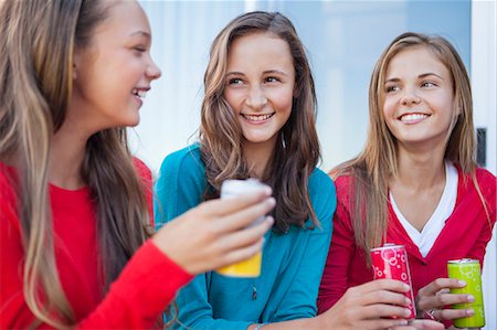 preteen blonde girl smiling - Close-up of three girls holding soft drink cans Stock Photo - Premium Royalty-Free, Code: 6108-06907040