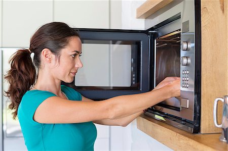 simsearch:6108-06167068,k - Woman putting food into a oven Foto de stock - Sin royalties Premium, Código: 6108-06907061