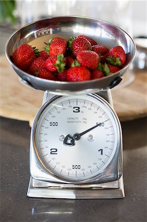 Strawberries on a weighing scale at a kitchen counter Photographie de stock - Premium Libres de Droits, Code: 6108-06907079