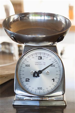 Close-up of a weighing scale at a kitchen counter Stock Photo - Premium Royalty-Free, Code: 6108-06907090