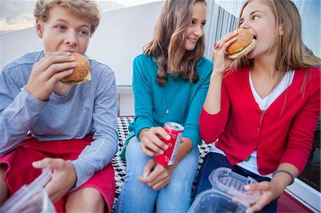 fast food - Friends enjoying fast food together Photographie de stock - Premium Libres de Droits, Code: 6108-06907020