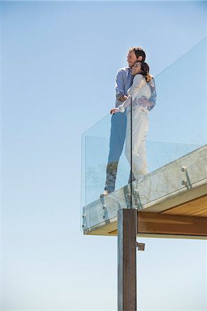 standing on terrace - Couple standing together on a terrace and smiling Stock Photo - Premium Royalty-Free, Code: 6108-06907177