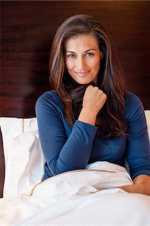 front view interior room - Woman smiling on the bed in a hotel room Stock Photo - Premium Royalty-Free, Code: 6108-06907175