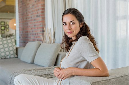 sofa - Portrait of a beautiful woman sitting on a couch Stock Photo - Premium Royalty-Free, Code: 6108-06907208