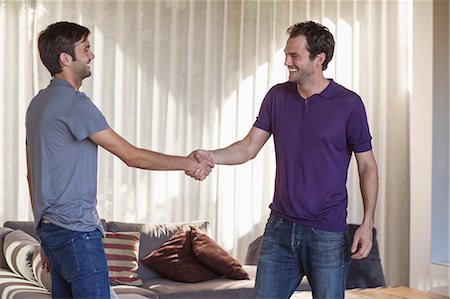 friends at table - Two friends shaking hands and smiling Stock Photo - Premium Royalty-Free, Code: 6108-06907348