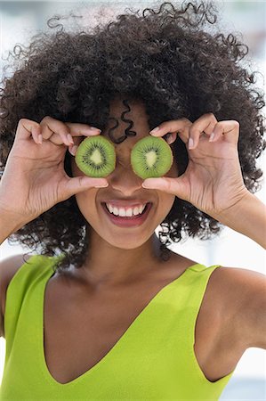 simsearch:6108-06908066,k - Woman holding kiwi fruits in front of her eyes Stock Photo - Premium Royalty-Free, Code: 6108-06907376