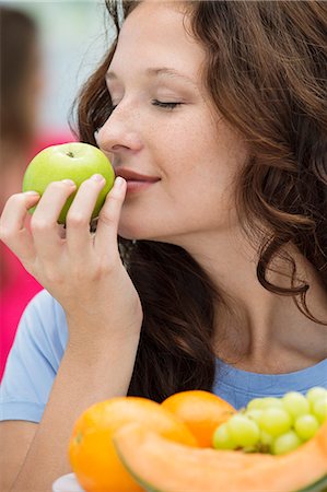 simsearch:6108-06907799,k - Close-up of a woman smelling a green apple Foto de stock - Royalty Free Premium, Número: 6108-06907409