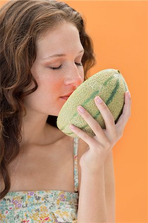 Close-up of a woman smelling melon Stock Photo - Premium Royalty-Free, Code: 6108-06907411