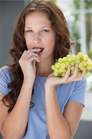 simsearch:6108-06908048,k - Portrait of a woman eating grapes Foto de stock - Sin royalties Premium, Código: 6108-06907416