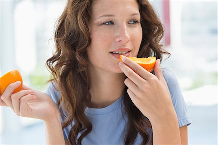 Close-up of a woman eating orange Photographie de stock - Premium Libres de Droits, Code: 6108-06907421