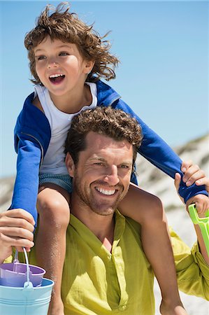father and sons on the beach - Man carrying his son on shoulders on the beach Stock Photo - Premium Royalty-Free, Code: 6108-06907558
