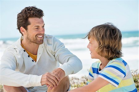 simsearch:6108-06907598,k - Man sitting with his son on the beach Photographie de stock - Premium Libres de Droits, Code: 6108-06907582