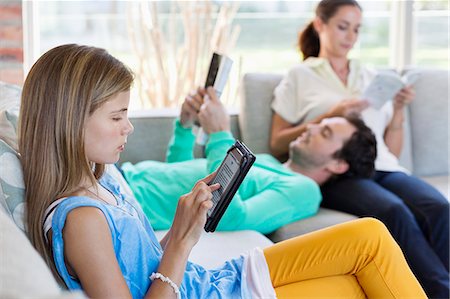 simsearch:6108-06904793,k - Girl using a digital tablet with her parents reading books at home Foto de stock - Sin royalties Premium, Código: 6108-06907603