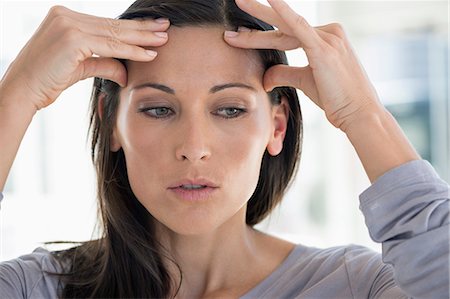 Close-up of a woman suffering from a headache Photographie de stock - Premium Libres de Droits, Code: 6108-06907746