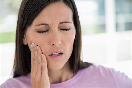 displeased - Woman suffering from a toothache Stock Photo - Premium Royalty-Free, Code: 6108-06907770