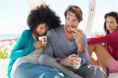 eating with friends not child not restaurant not outdoor - Couple having coffee with their friend in the background Stock Photo - Premium Royalty-Free, Code: 6108-06907715