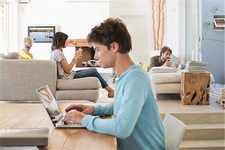 simsearch:6108-06907738,k - Man using a laptop with his friends using electronic gadgets in background Foto de stock - Royalty Free Premium, Número: 6108-06907728