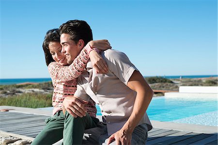 relaxing pool water - Romantic couple sitting on a boardwalk on the beach Stock Photo - Premium Royalty-Free, Code: 6108-06907734