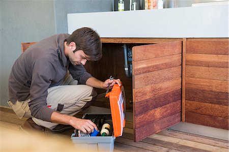 plumber working on side photos - Man repairing a kitchen sink Stock Photo - Premium Royalty-Free, Code: 6108-06907840