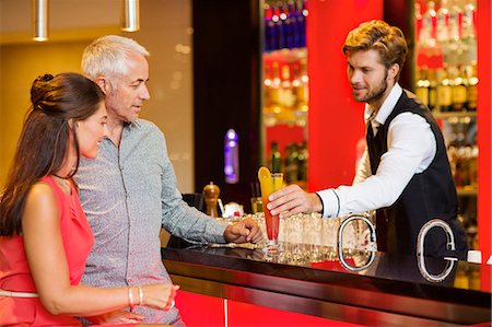 simsearch:6108-06904980,k - Bartender serving drink to a couple at bar counter Foto de stock - Sin royalties Premium, Código: 6108-06907856