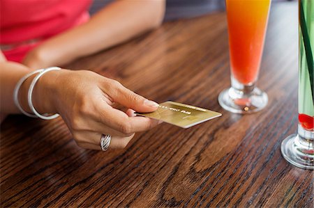 Woman paying with a credit card on a table in a restaurant Photographie de stock - Premium Libres de Droits, Code: 6108-06907864